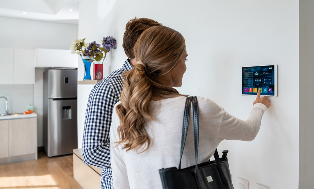 Back view of latin american couple activating their smart home system